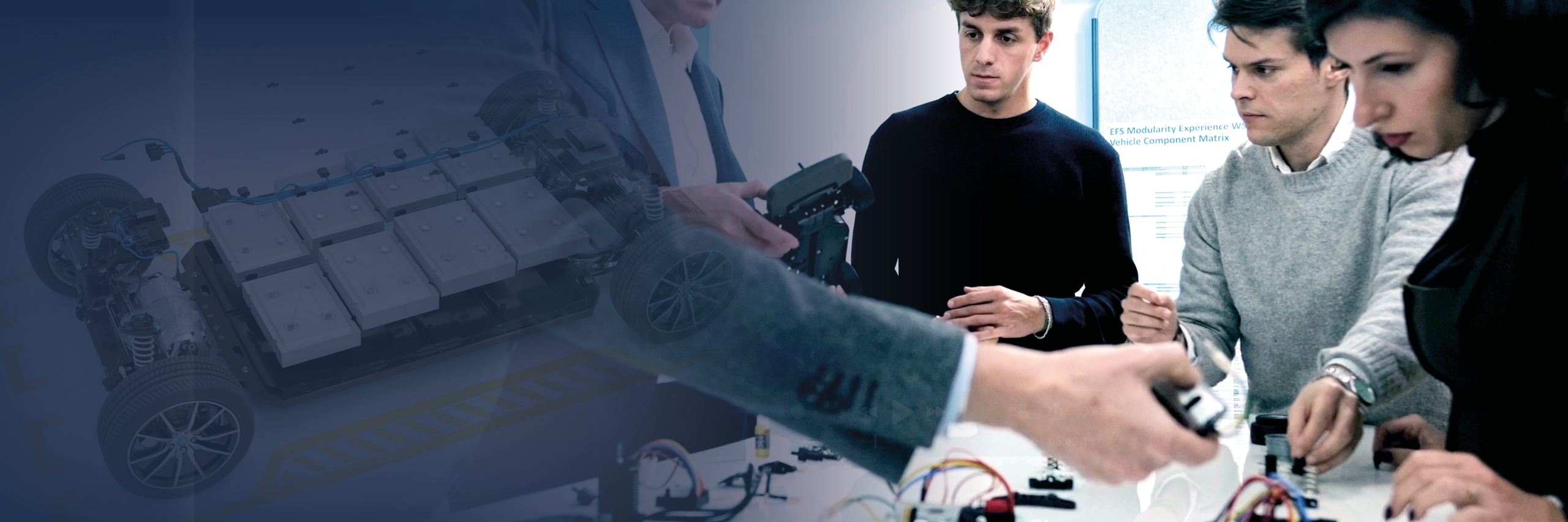 Das Bild zeigt mehrere Personen, die konzentriert an einem Projekt arbeiten. Im Vordergrund stehen drei Personen an einem Tisch, auf dem elektronische Bauteile, Kabel und Werkzeuge liegen. Eine Frau rechts im Bild justiert präzise ein Bauteil, während ein Mann daneben mit einem Schraubendreher arbeitet. Ein weiterer Mann im Hintergrund beobachtet aufmerksam den Arbeitsprozess. Links im Bild ist, teils transparent eingeblendet, die technische Darstellung eines Fahrgestells mit Elektrobatterien und Verkabelung zu sehen.