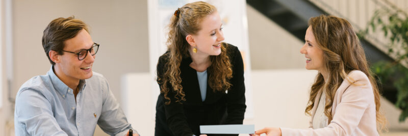 3 People chatting in a modern light EFS Consulting Office space.