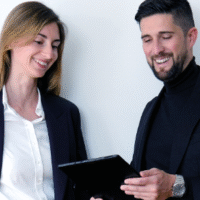 Michael Rinda and another consultant looking at a tablet and smile.