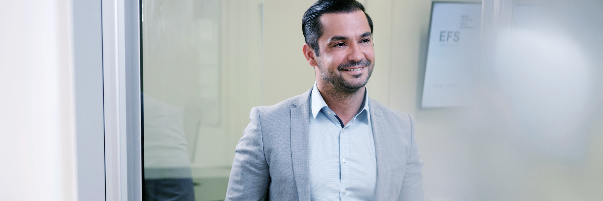 Consultant standing infront of a scrren that shows the blue EFS Consulting logo blurry