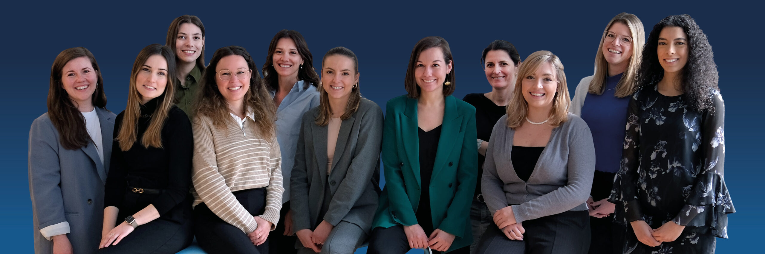 Auf diesem Bild sind 11 Frauen zu sehen, die alle in die Kamera lächeln.