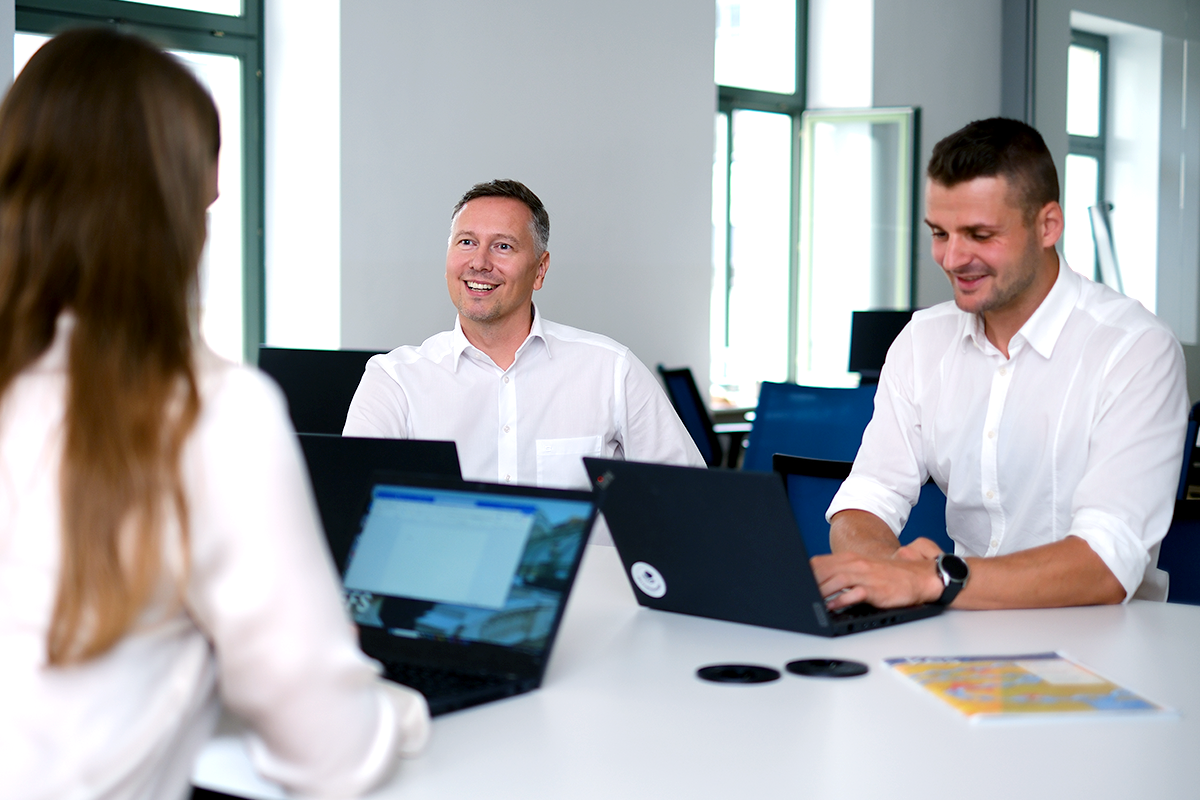 EFS Infomation Security Expert:innen im Gespräch in einem hellen Meetingraum.