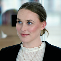 Consultant Headshot hinter einen einer Glaswand in dem hellen EFS Consulting Office.