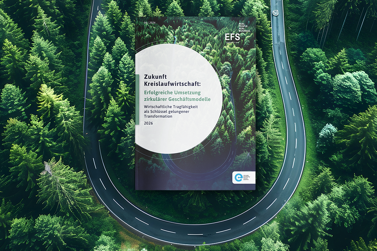 Luftaufnahme eines dichten, grünen Nadelwaldes mit einer kurvenreichen Straße, die eine nahezu geschlossene Schleife bildet und an den Kreislaufgedanken erinnert. In der Mitte ist eine Magazin- oder Berichtstitelseite eingeblendet. Darauf steht: „Zukunft Kreislaufwirtschaft: Erfolgreiche Umsetzung zirkulärer Geschäftsmodelle – Wirtschaftliche Tragfähigkeit als Schlüssel gelungener Transformation, 2026“. Oben rechts ist das EFS-Logo mit dem Slogan „Real People. Real Business.“ sichtbar. Unten rechts befindet sich ein weiteres Kreislauf-Logo. Die Gestaltung betont Nachhaltigkeit und Zirkularität durch die Kombination aus Naturmotiv und geschlossener Straßenform.
