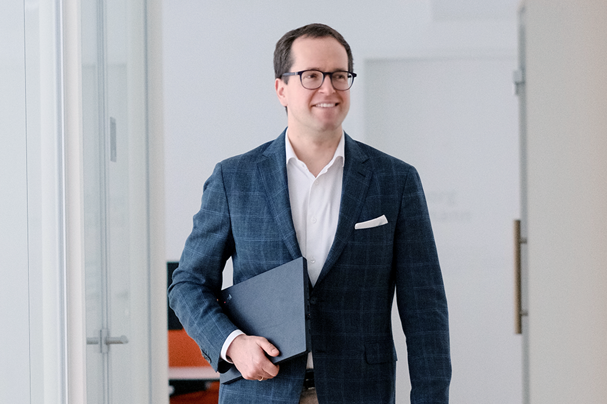 Alan Szwajkowski mit Latop in der Hand im EFS Office.